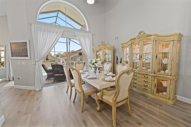 dining room with a high ceiling and hardwood / wood-style flooring