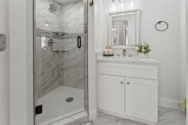 bathroom featuring a shower with shower door and vanity