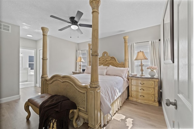 bedroom with light wood-type flooring, ceiling fan, ensuite bathroom, and a textured ceiling