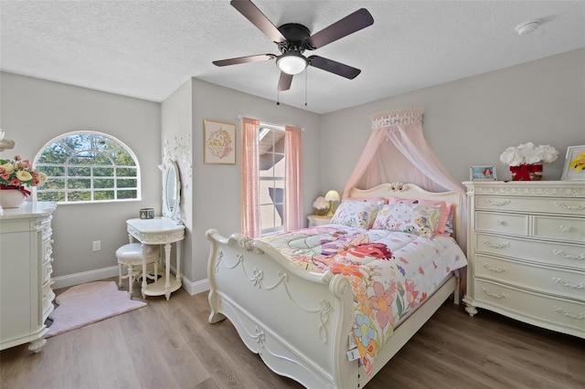 bedroom with ceiling fan, a textured ceiling, and hardwood / wood-style flooring