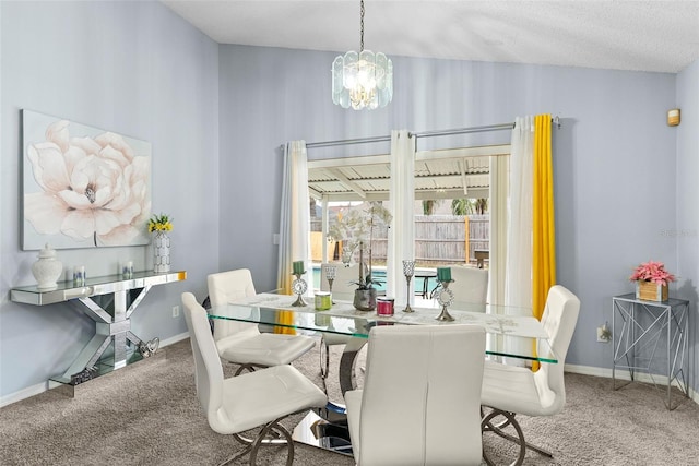 carpeted dining area with a notable chandelier and a textured ceiling