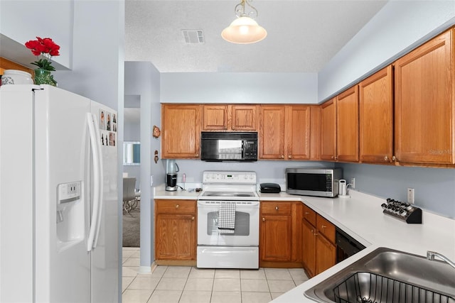 kitchen with pendant lighting, sink, white appliances, a textured ceiling, and light tile patterned floors