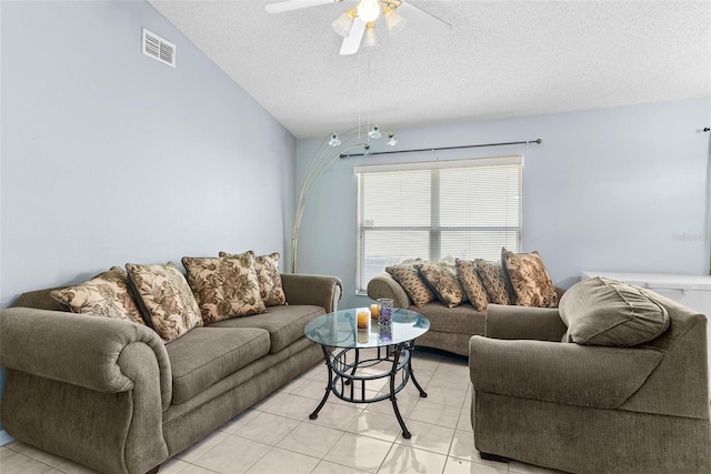 tiled living room featuring a textured ceiling, ceiling fan, and lofted ceiling