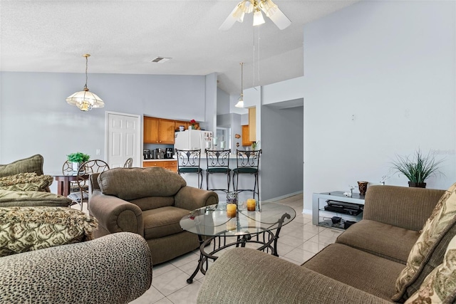 living room featuring a textured ceiling, light tile patterned flooring, ceiling fan with notable chandelier, and high vaulted ceiling