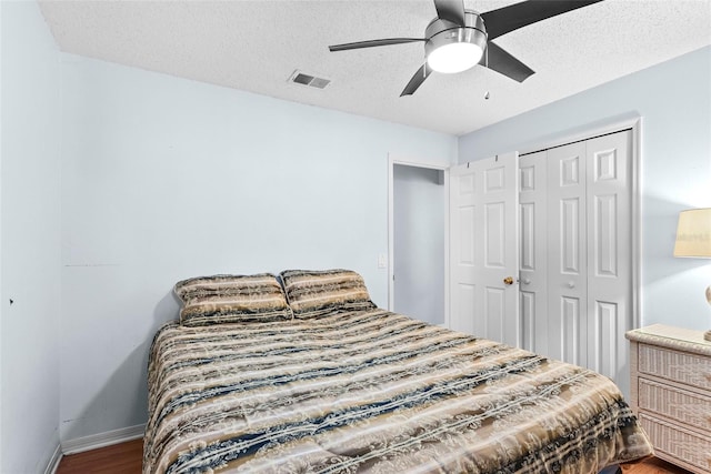 bedroom featuring ceiling fan, wood-type flooring, a closet, and a textured ceiling