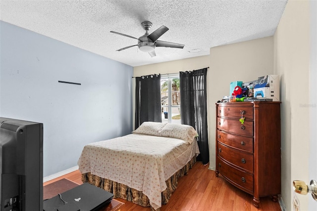 bedroom with ceiling fan, a textured ceiling, and light hardwood / wood-style flooring