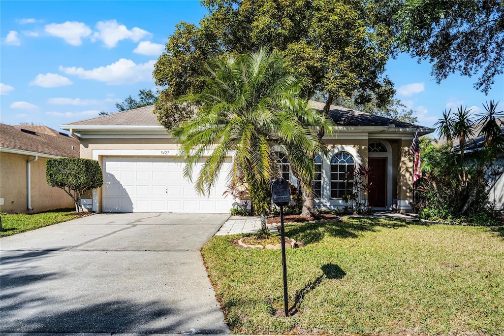 ranch-style home with a front lawn and a garage