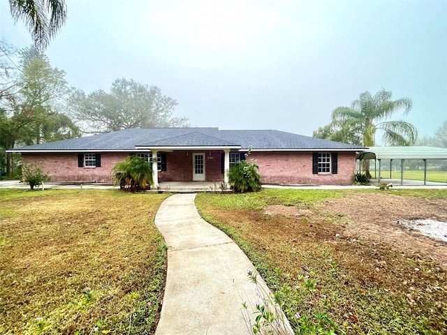 ranch-style home featuring a front yard and a carport