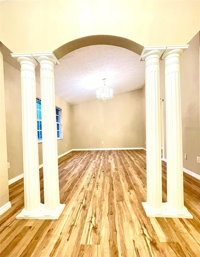 interior space featuring hardwood / wood-style flooring, a textured ceiling, and a notable chandelier