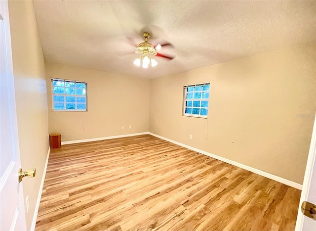 spare room with a textured ceiling, light hardwood / wood-style floors, and ceiling fan