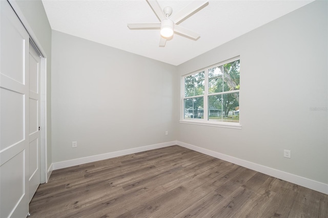 unfurnished bedroom featuring ceiling fan, dark wood-type flooring, and a closet