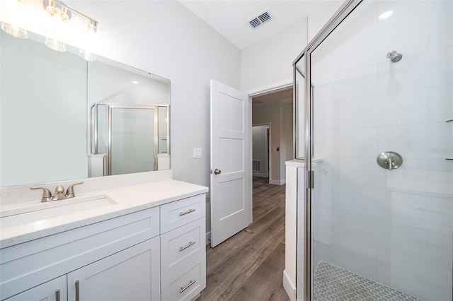 bathroom featuring walk in shower, hardwood / wood-style floors, and vanity