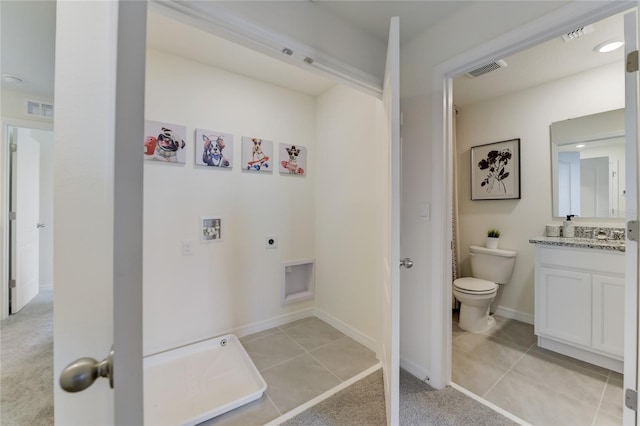 bathroom with tile patterned flooring, vanity, and toilet