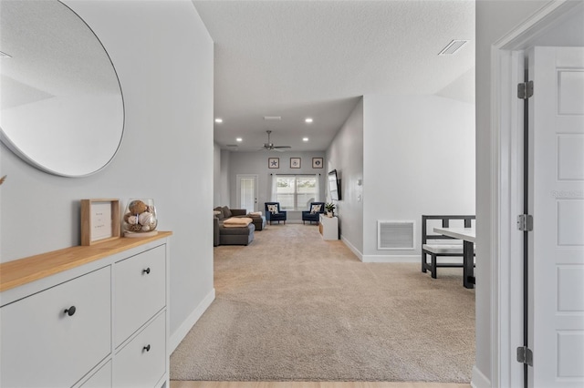 corridor with light colored carpet, a textured ceiling, and vaulted ceiling