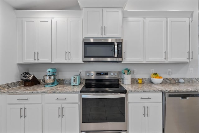 kitchen featuring light stone counters, white cabinetry, and stainless steel appliances