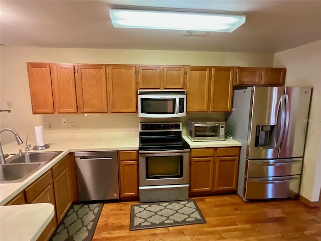 kitchen with sink, light hardwood / wood-style flooring, and stainless steel appliances