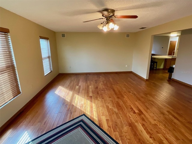 spare room with ceiling fan, a textured ceiling, and hardwood / wood-style flooring