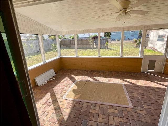 unfurnished sunroom with ceiling fan and vaulted ceiling