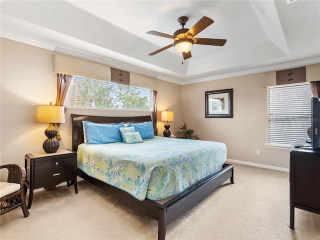 carpeted bedroom featuring ceiling fan, a tray ceiling, and ornamental molding