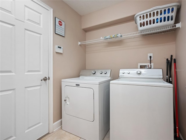 laundry room with washer and dryer and light tile patterned flooring