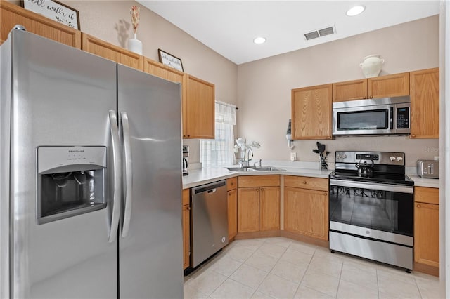 kitchen with sink, light tile patterned floors, and stainless steel appliances