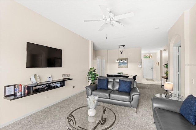 living room featuring ceiling fan with notable chandelier and carpet floors