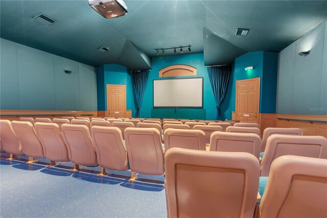 cinema room with a textured ceiling and track lighting