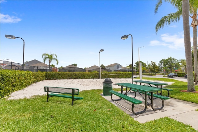 surrounding community with volleyball court and a lawn