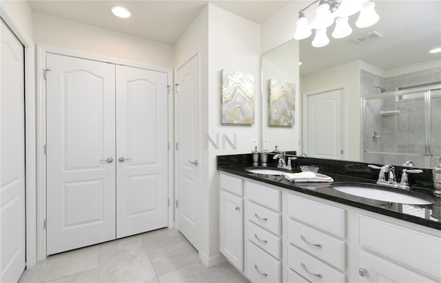 bathroom with tile patterned flooring, a shower with shower door, and vanity