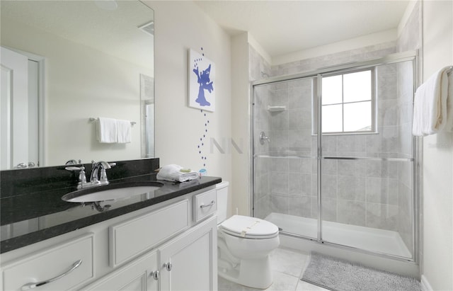 bathroom with toilet, vanity, tile patterned floors, and walk in shower