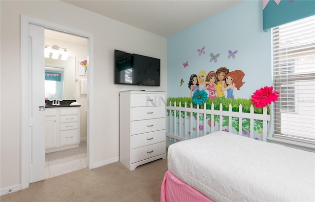 bedroom with sink, light colored carpet, and ensuite bathroom