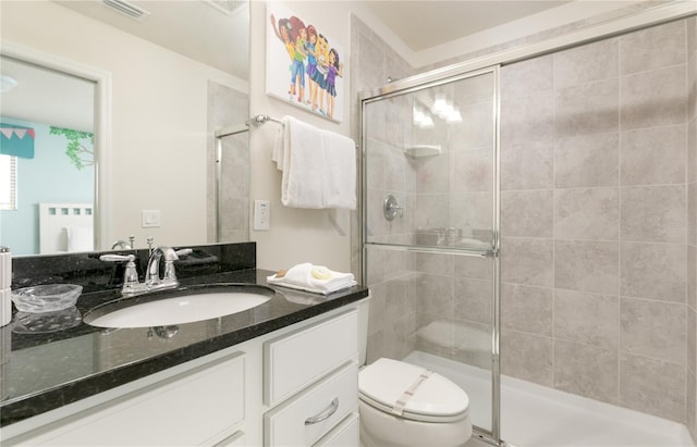 bathroom featuring an enclosed shower, vanity, and toilet