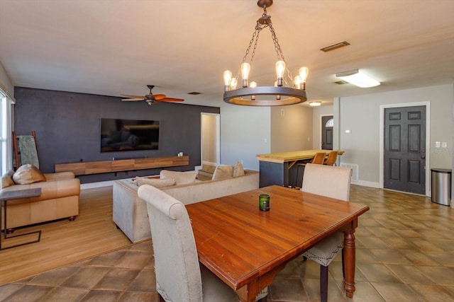 dining room with ceiling fan with notable chandelier