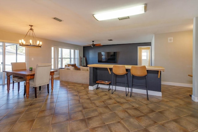 dining space featuring ceiling fan with notable chandelier