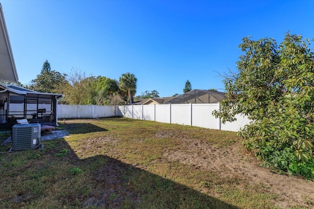 view of yard featuring central AC unit and a sunroom