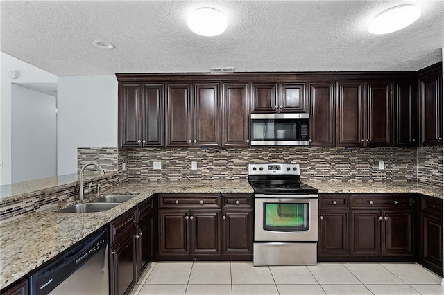 kitchen with appliances with stainless steel finishes, dark brown cabinets, and sink