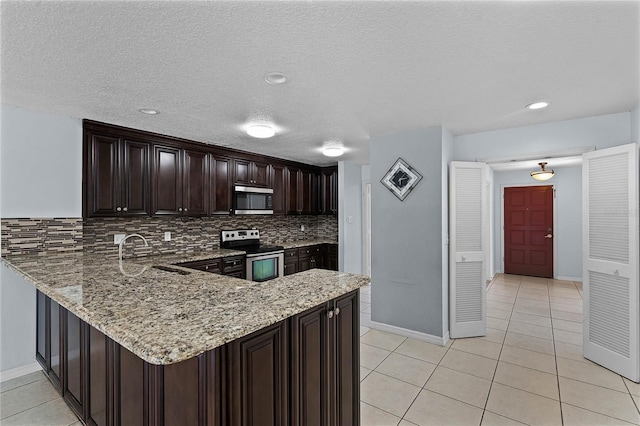 kitchen with light stone counters, light tile patterned floors, tasteful backsplash, appliances with stainless steel finishes, and sink