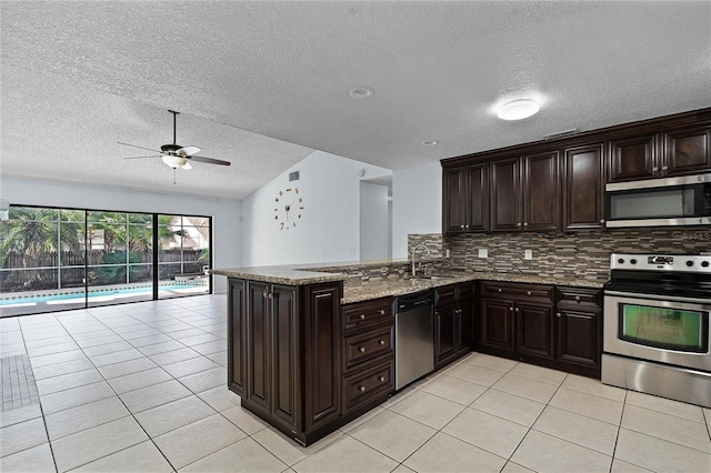 kitchen featuring light tile patterned flooring, ceiling fan, kitchen peninsula, decorative backsplash, and appliances with stainless steel finishes