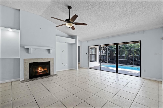 unfurnished living room with a fireplace, a textured ceiling, lofted ceiling, light tile patterned flooring, and ceiling fan