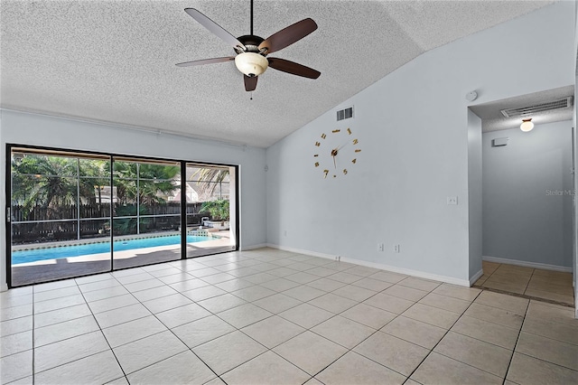 tiled empty room with lofted ceiling, a textured ceiling, and ceiling fan