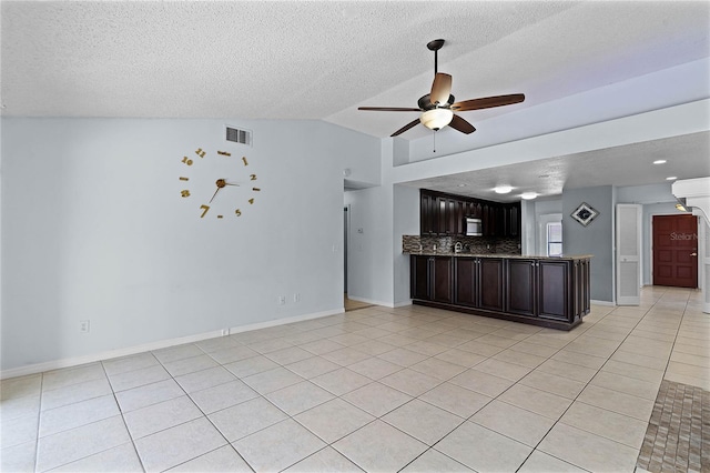 unfurnished living room featuring lofted ceiling, light tile patterned flooring, a textured ceiling, and ceiling fan