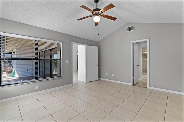 empty room with lofted ceiling, light tile patterned flooring, and ceiling fan