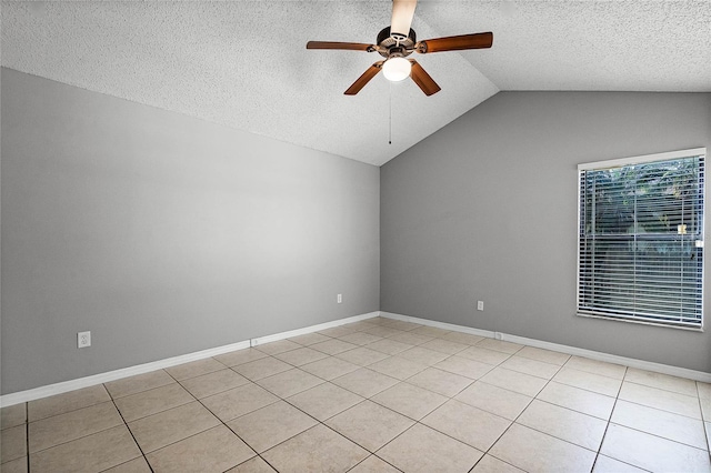 spare room featuring lofted ceiling, a textured ceiling, ceiling fan, and light tile patterned flooring