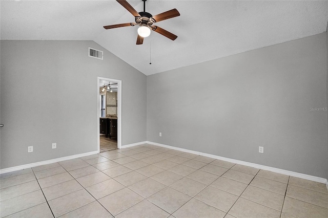 unfurnished room featuring ceiling fan, vaulted ceiling, and light tile patterned flooring