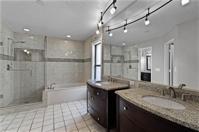 bathroom featuring a textured ceiling, vanity, tile patterned floors, and independent shower and bath