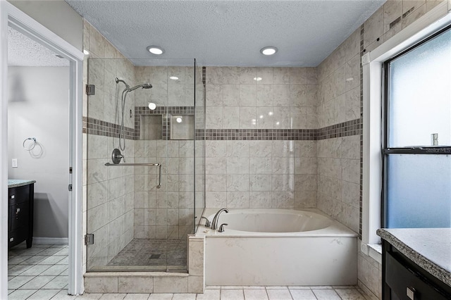 bathroom with a textured ceiling, plus walk in shower, tile patterned floors, and vanity