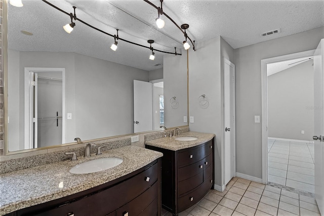 bathroom featuring a textured ceiling, vanity, and tile patterned floors