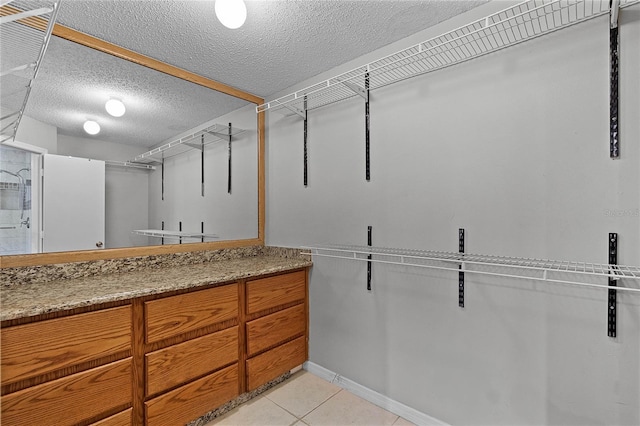 walk in closet with light tile patterned floors