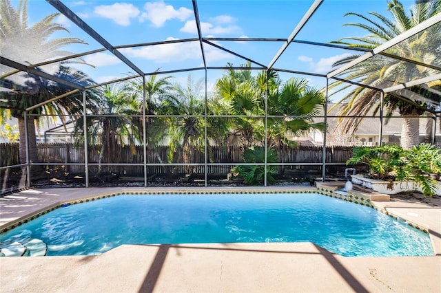 view of swimming pool featuring a patio and glass enclosure