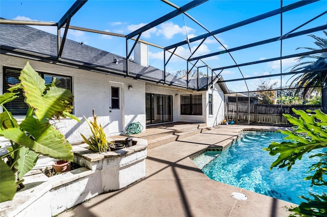 view of pool with glass enclosure and a patio